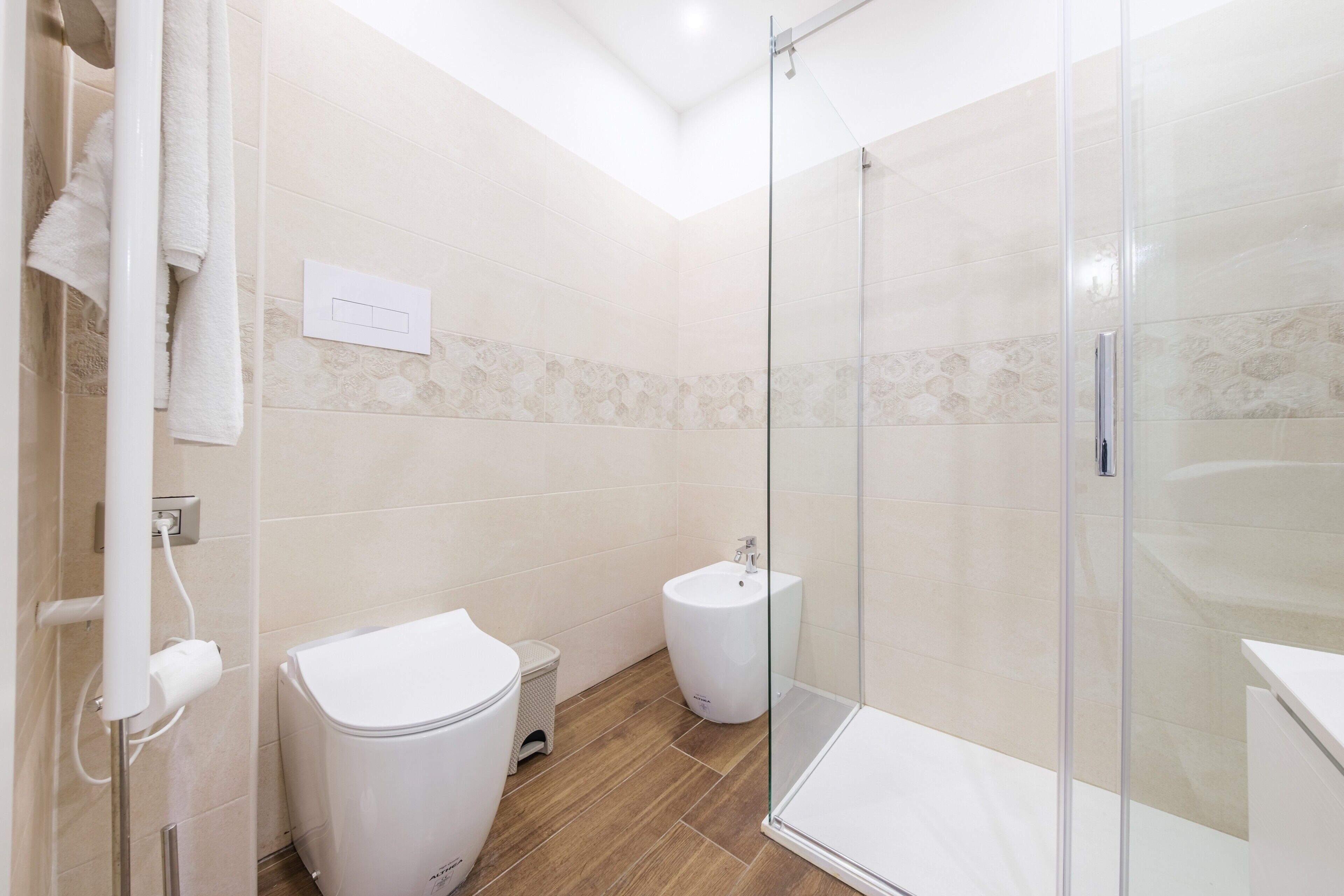 Un bagno moderno con cabina doccia in vetro, un water e un bidet.