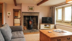 A cozy living room with a fireplace, a television, and a sofa. - Stone &amp; Fleece Cottage (Holmfirth)