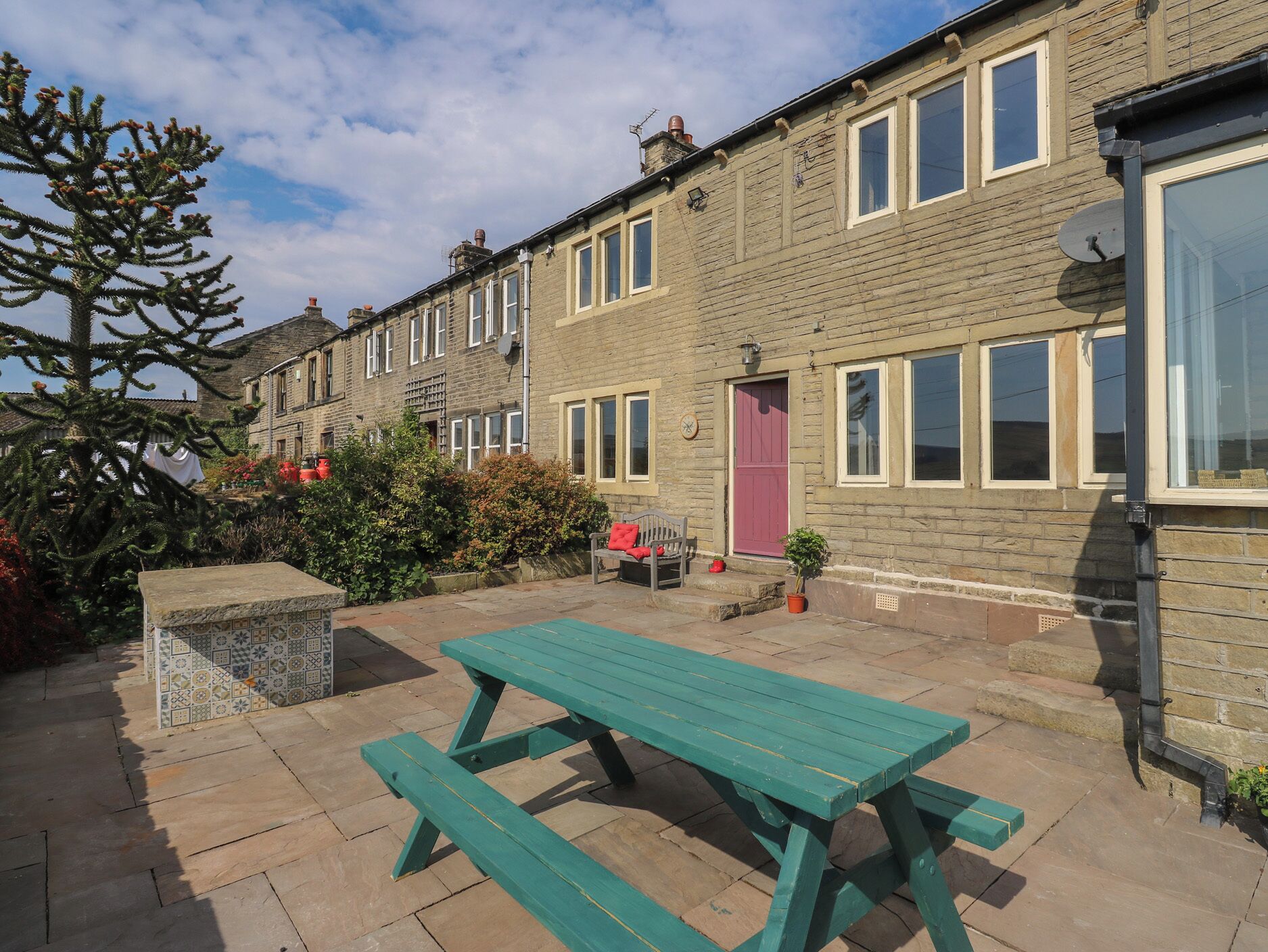 A row of terraced houses with a picnic table in the foreground.