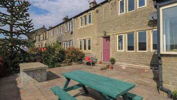 A row of terraced houses with a picnic table in the foreground.