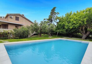 A swimming pool with a house in the background.