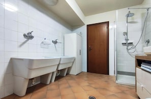Un baño con dos lavamanos, ducha y puerta.