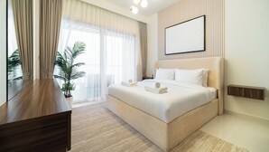 Een moderne hotelkamer met een groot bed, een bureau en een potplant.