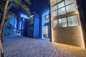 A modern building with a blue-lit entrance, a visible staircase, and a number '103' on the wall. - XO Canggu Adults Only (Canggu)