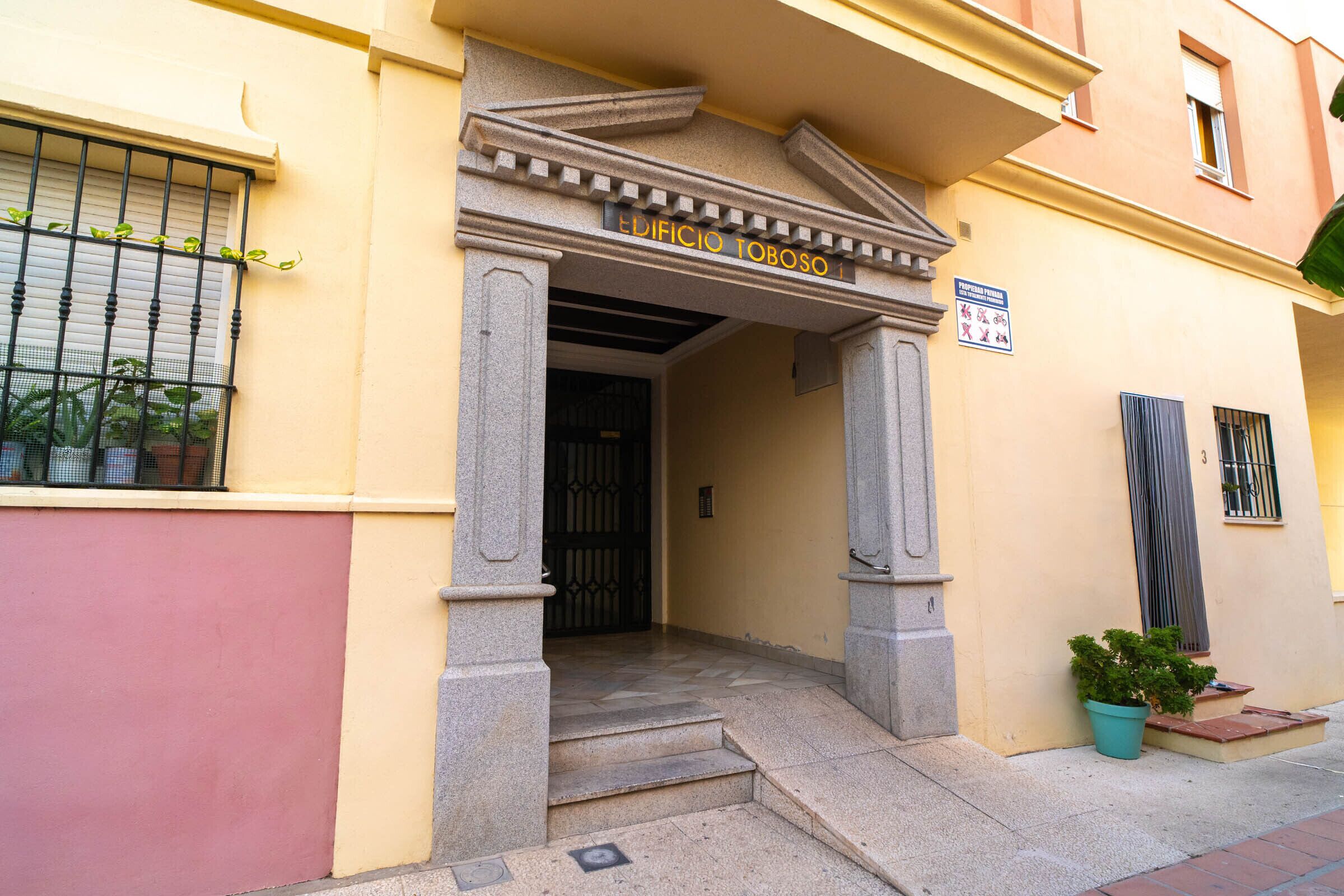 A building entrance with a sign reading 'DIFICIO TOBOSO' and a private property sign.
