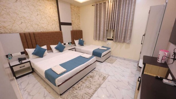 Une chambre d’hôtel avec deux lits, un bureau, une armoire et une salle de bain.