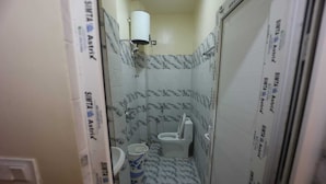 Une petite salle de bain avec des toilettes, un lavabo et une douche.