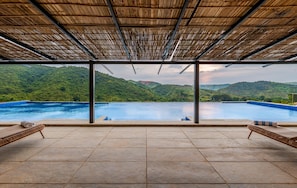 A poolside area with a view of a mountain landscape.