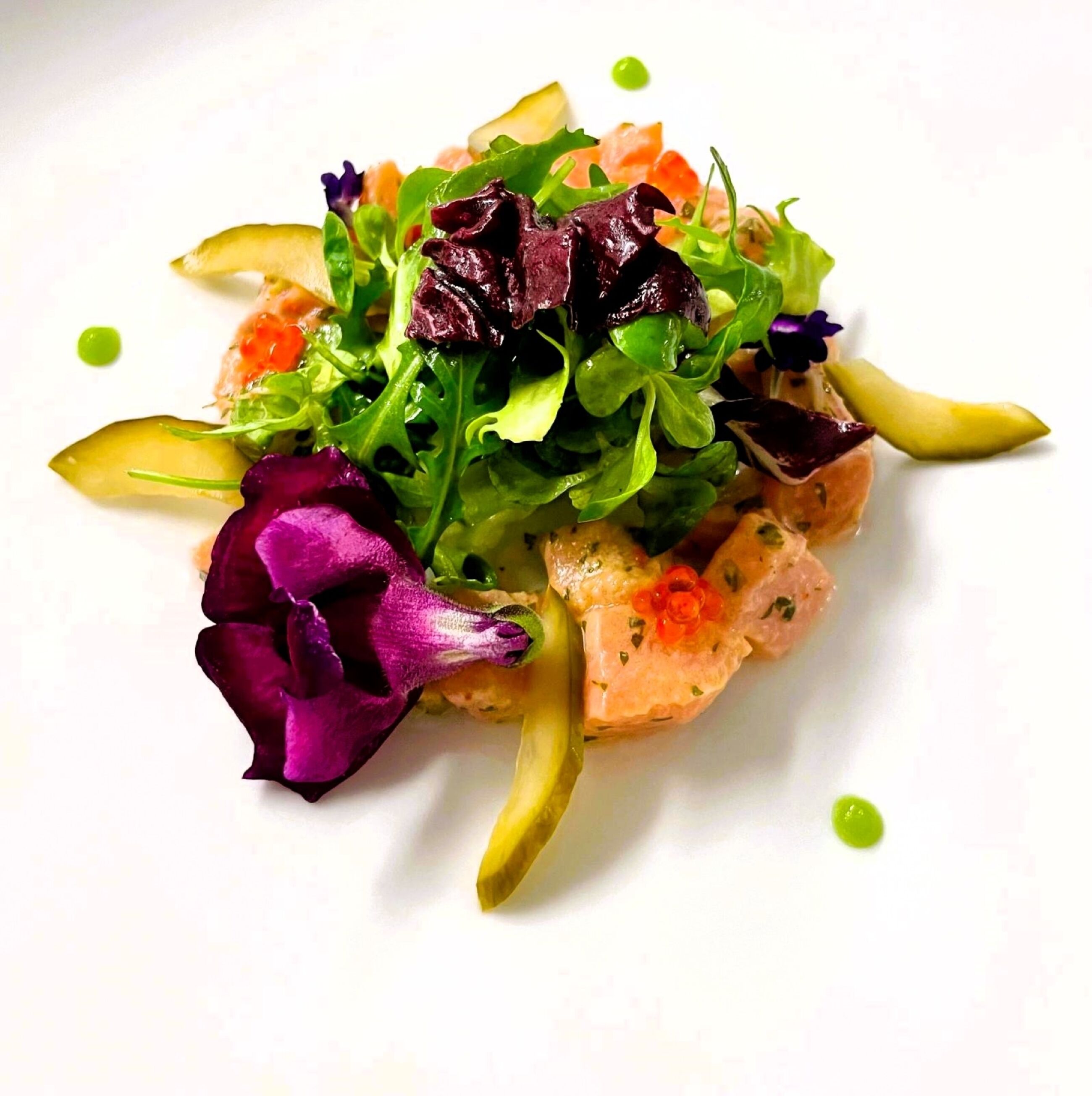 Un plato de comida con varios vegetales y salmón.