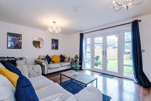 A living room with a sofa, coffee table, and a chandelier. - 5Bed 3.5Bath | MnthlyDisc% | BigDriveWay |Chorlton (Greater Manchester)