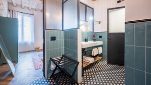 A bathroom with a shower, a sink with a mirror, and a towel rack.
