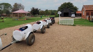 A gravel path leading to a barn with a sheep shuttle sign. - Molly (Woodbridge)