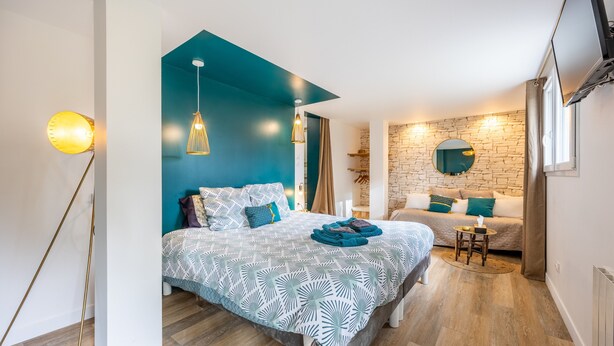 Camera da letto moderna con letto, comodino e parete decorata con pietra.