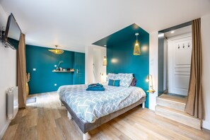 Ein modernes Schlafzimmer mit einem Bett, einem Fernseher und einer Treppe.