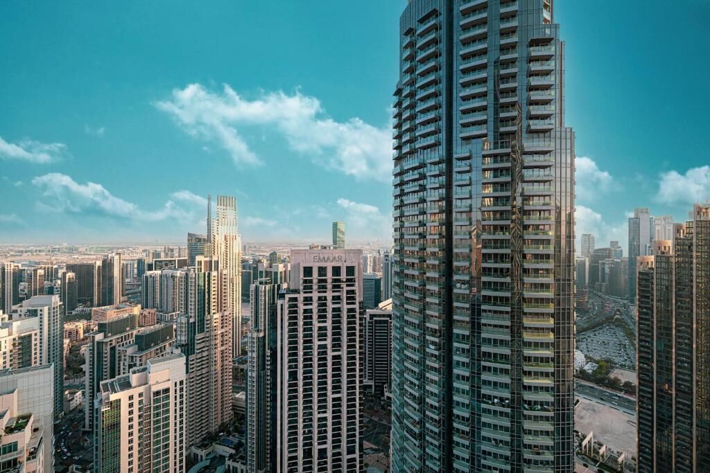 A high-rise building with a modern architectural design, surrounded by other tall buildings in a dense urban area.