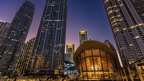A modern urban skyline with high-rise buildings and a distinctive curved glass building.