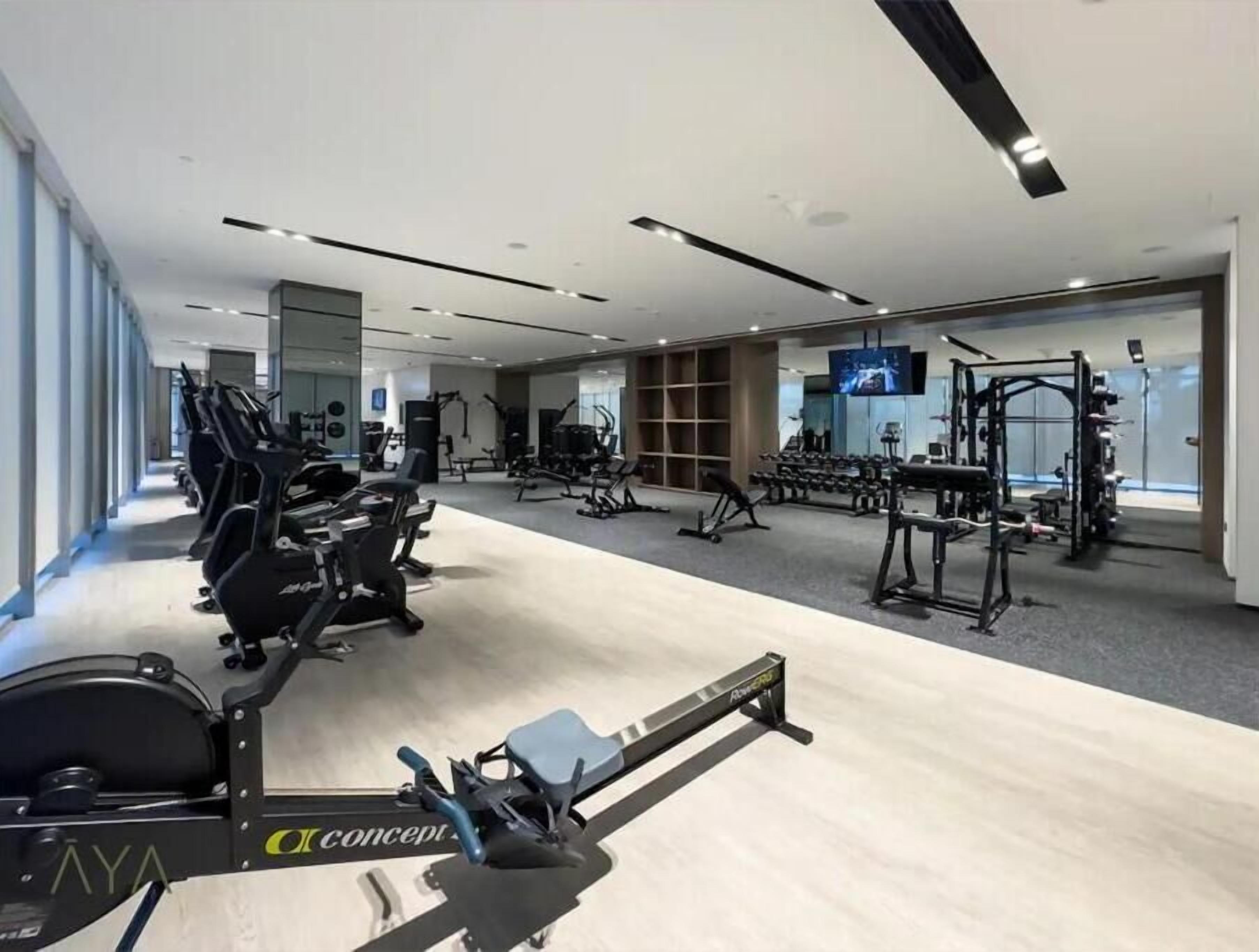 A modern gym with various exercise equipment, including treadmills and weight machines.