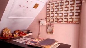 A reception desk with a calendar, a small shrine, and a wall-mounted phone. - Hotel Raj Ratan (Kanpur)