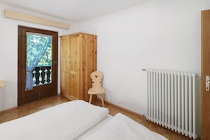 Ein Schlafzimmer mit einem Holzschrank, einer Heizung und einem Fenster mit Blick.