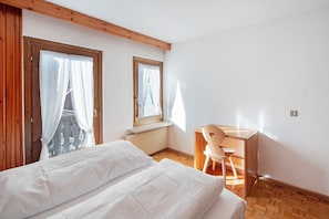 Une chambre à coucher avec un lit, un bureau en bois et une chaise.