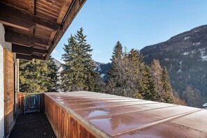 Una terraza de madera con vistas a un paisaje montañoso.