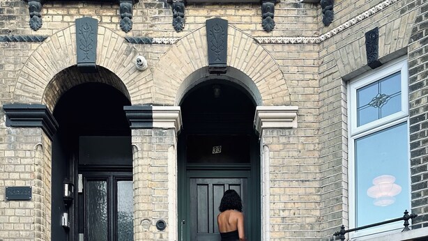 A black-clad woman descending a black and white staircase leading to a door marked "33". - Margate Manor (Margate)