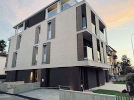 A modern multi-story building with a flat roof, large windows, and a flat facade.