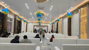 A spacious hall with rows of white chairs, a central stage with a 'WELCOME BABY' sign, and decorative balloons. - Dream House Club And Resort (Gonda)