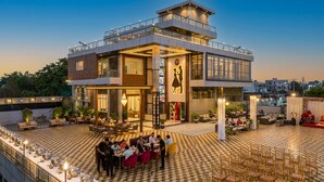 A modern hotel with a rooftop dining area, outdoor seating, and a checkered floor pattern. - Dream House Club And Resort (Gonda)
