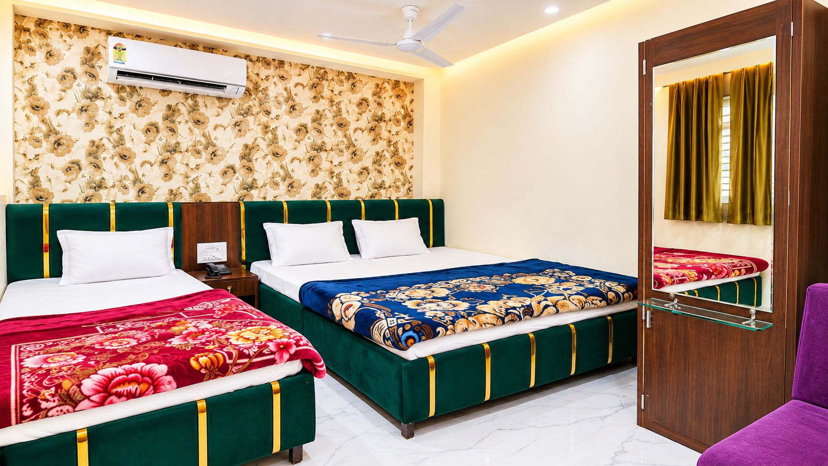 A hotel room with two beds, an air conditioning unit, a ceiling fan, a mirror, and a wooden wardrobe.