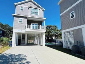 A two-story residential building with a covered entryway and a balcony.