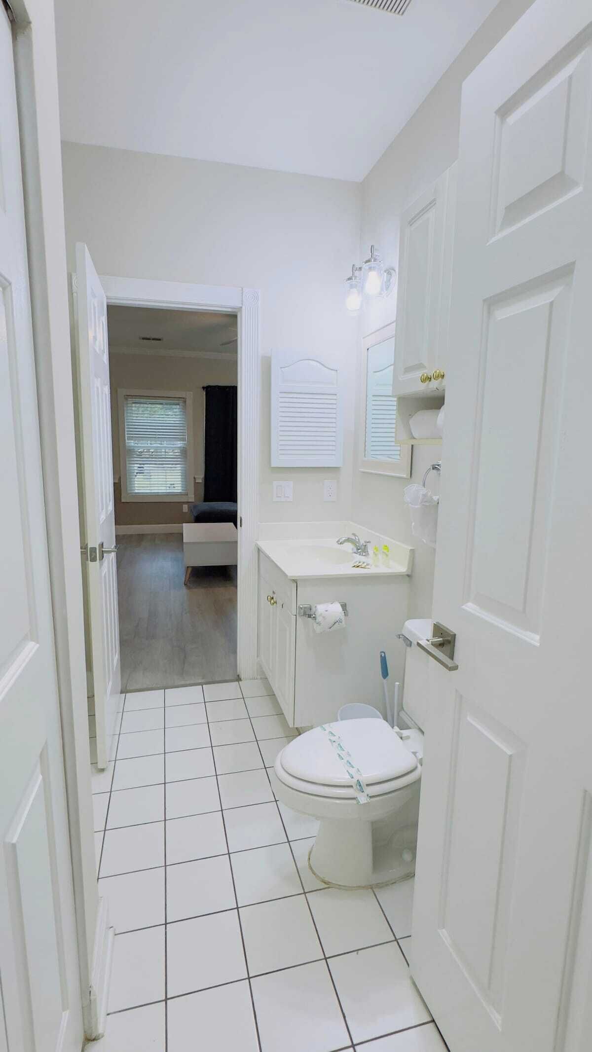 Een badkamer met toilet, wastafel en spiegel.