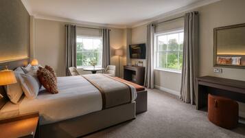 Une chambre d’hôtel avec un grand lit, un bureau, une chaise, une télévision et une vue sur l’extérieur.