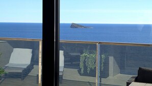 Ein Balkon mit freiem Blick auf das Meer und eine entfernte Insel.