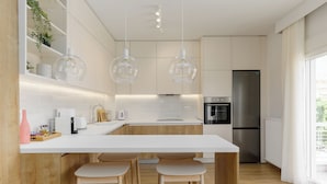 A modern kitchen with a central island, wooden stools, pendant lighting, and stainless steel appliances. - Bel Air by halu (Thessaloniki)