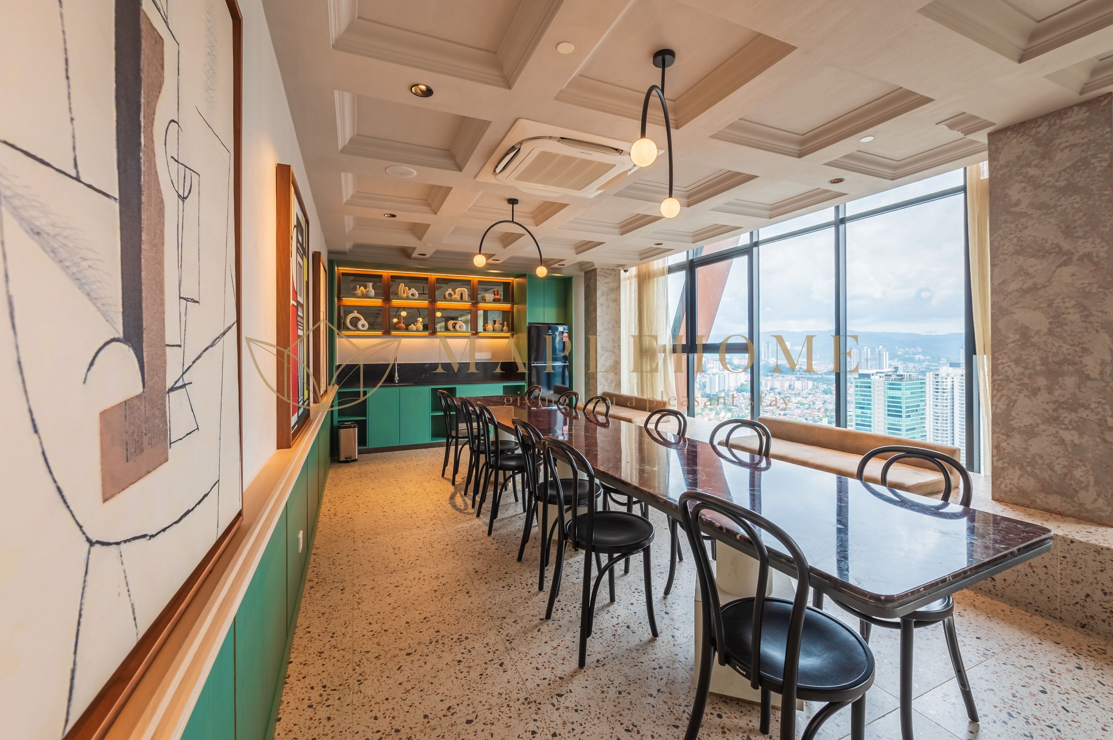 Una cocina moderna con una barra alargada, sillas negras y vistas de la ciudad a través de amplios ventanales.