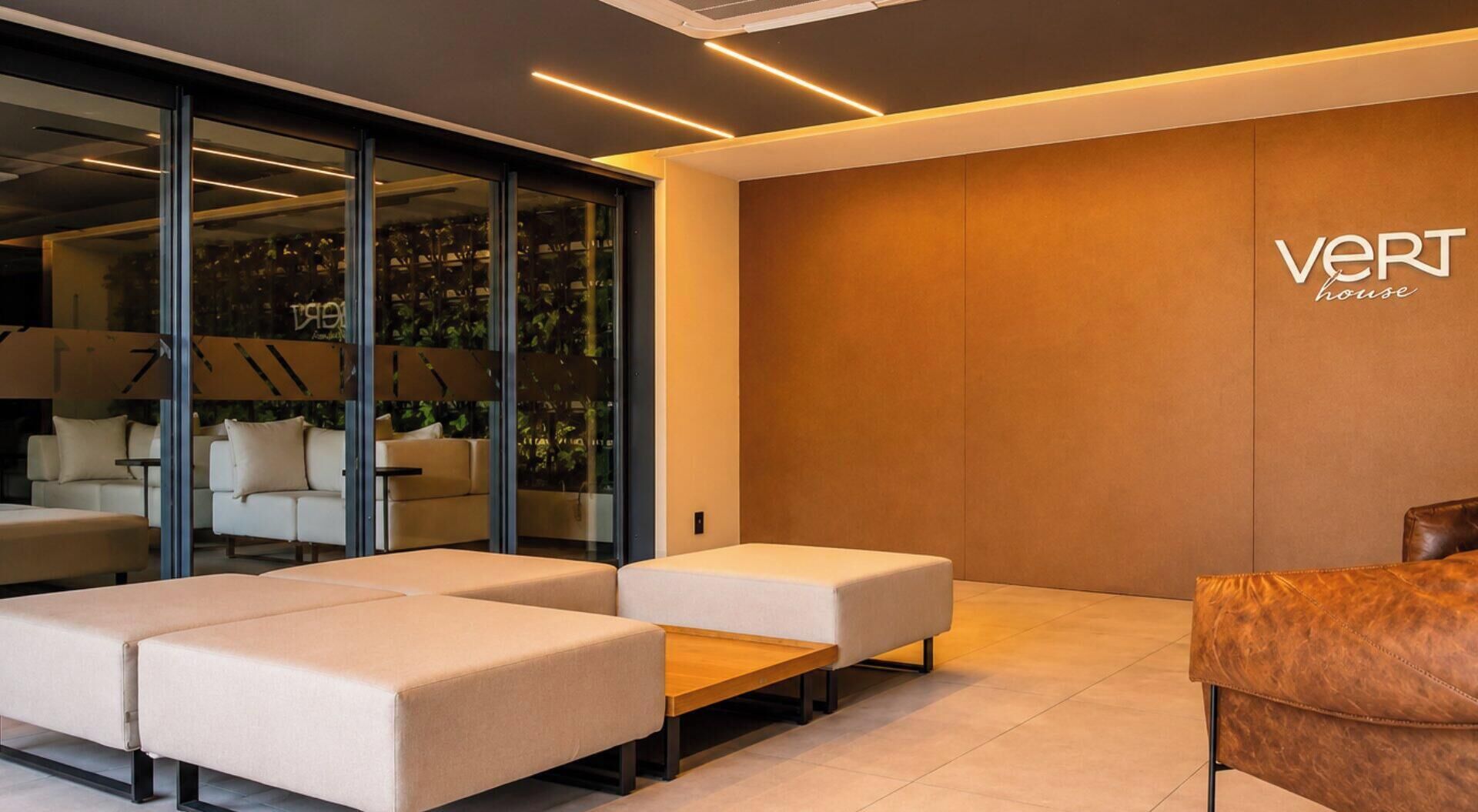 Un interior modern amb un sofà, una taula baixa de fusta i un butac armchair de pell.