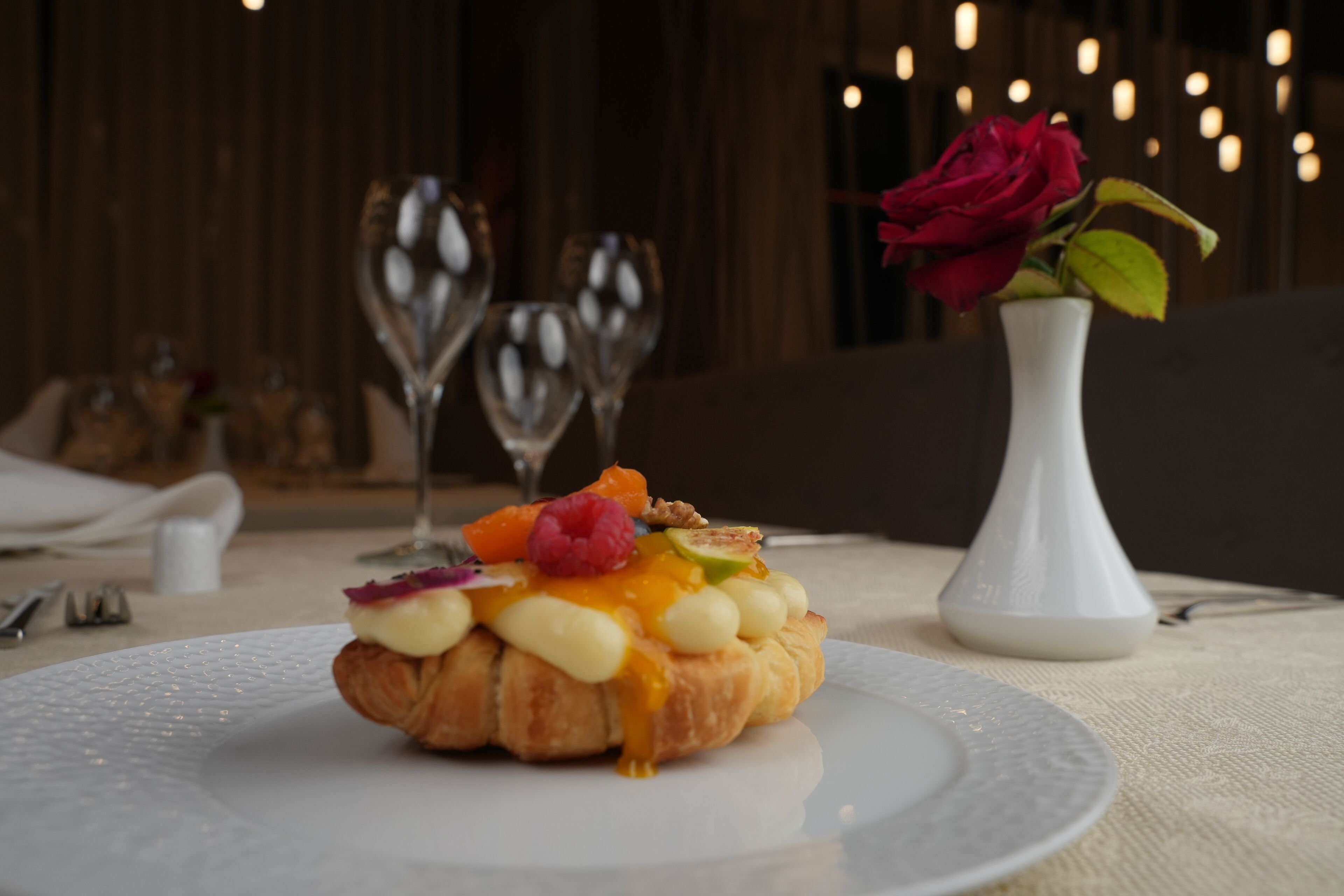 Un postre a un plat amb una rosa dins d'un vas.