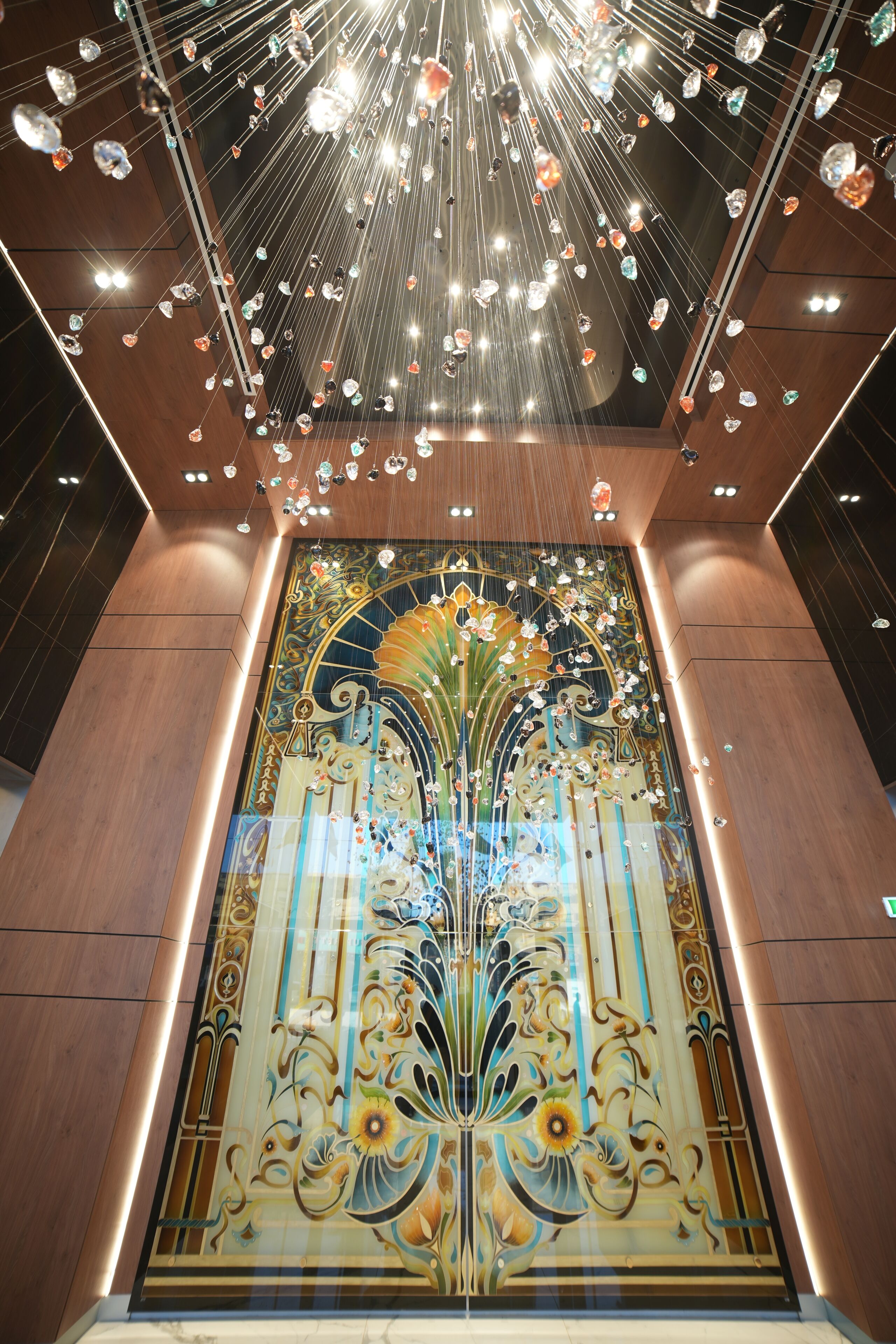 A ceiling with hanging crystals and a decorative glass panel with floral patterns.