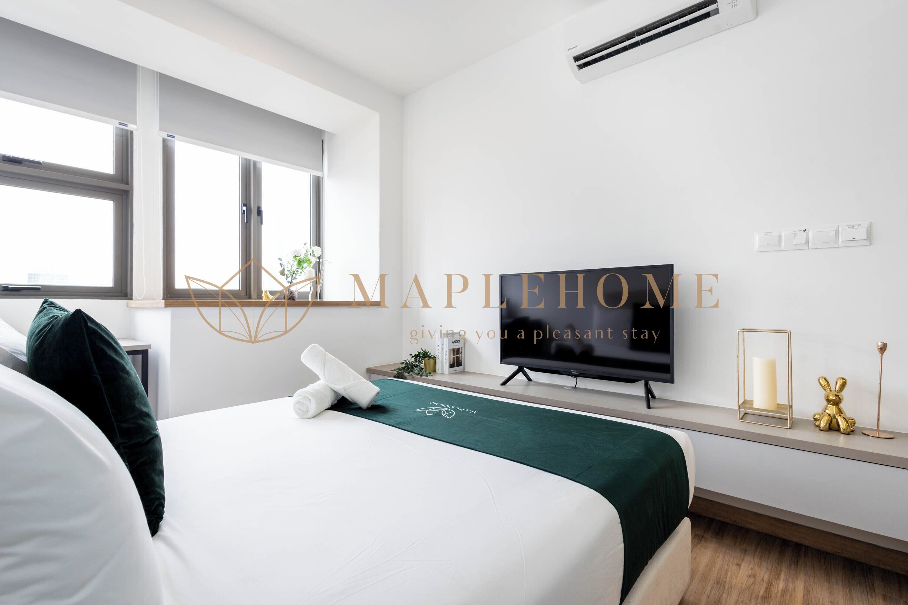 Habitación de hotel con cama, televisor, ventana y aire acondicionado de pared.