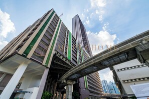 Un edificio alto con un puente peatonal sobre él.