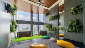 Ein modernes Interieur mit Holzbalkendecke, grünen Wandstecklingen und Blick auf die Skyline der Stadt.