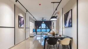 A modern dining area with a long table, chairs, and a view of the city through large windows.