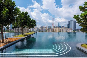 A swimming pool with a city skyline in the background. - M Vertica Premier Suites Kuala Lumpur (Kuala Lumpur)