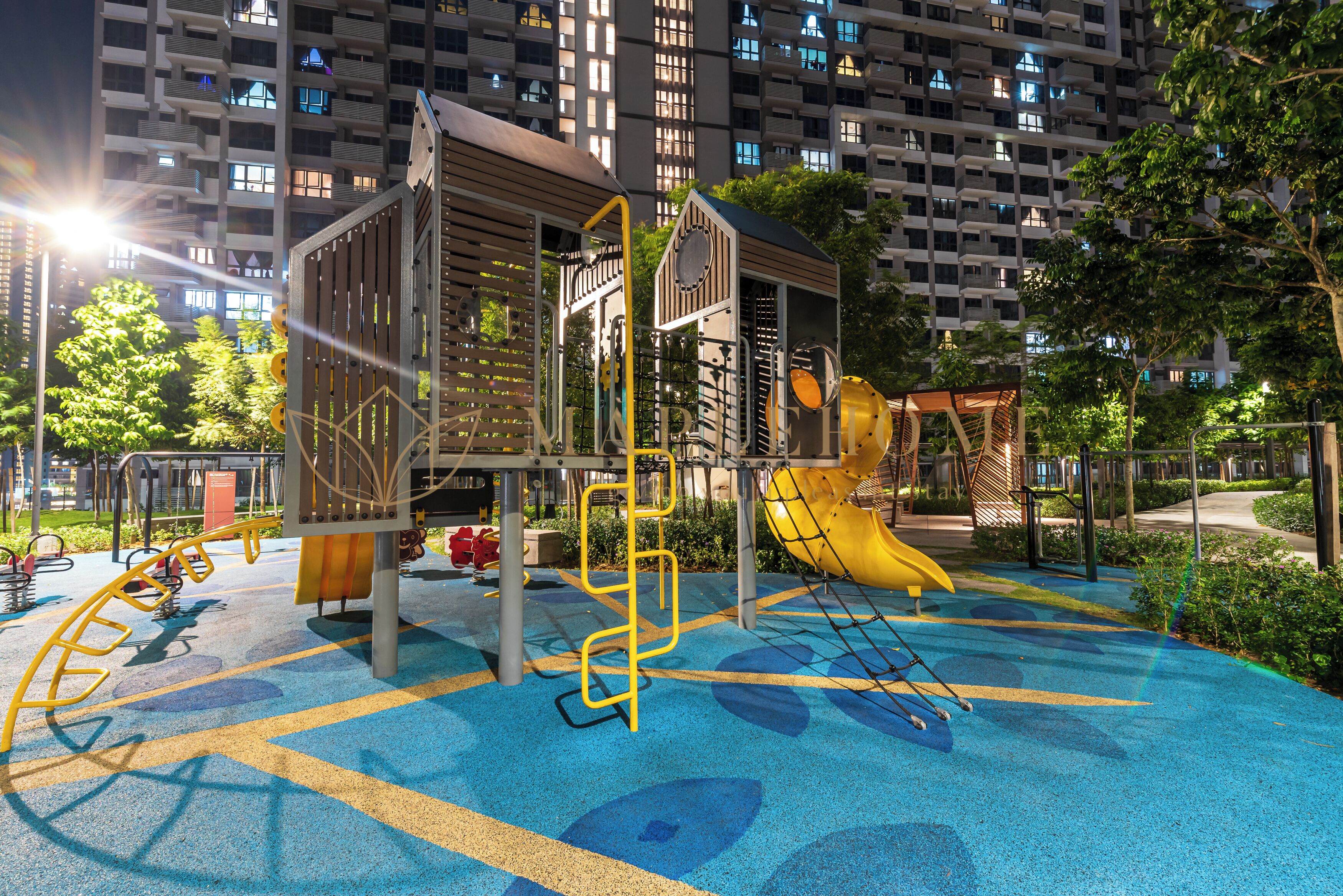 A playground with various play structures, including a slide and climbing frames, surrounded by a blue and yellow play area.