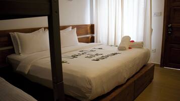 A neatly made bed with a wooden headboard, white linens, and a message written on the bedspread.