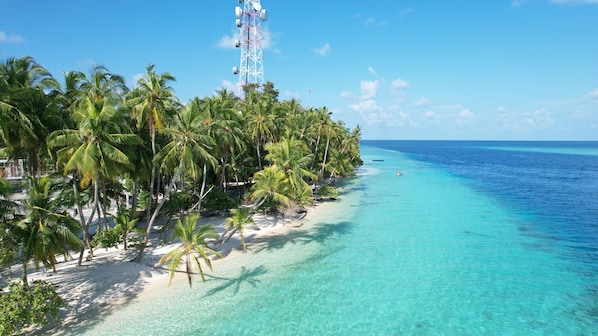 Una playa cerca, arena blanca, sillas reclinables de playa, sombrillas