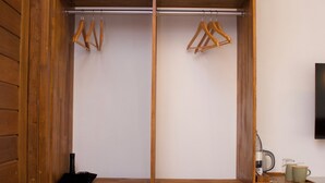 A wooden wardrobe with multiple shelves, a hanging rod, and a small safe. - Oshi Boutique  (Felidhoo)