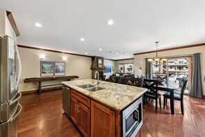 A modern kitchen with a granite countertop, stainless steel appliances, and wooden cabinets.