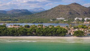 Une zone côtière avec une plage, un lac et des montagnes en arrière-plan.